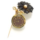 Reloj de bolsillo para dama elaborado en oro de 18K. Tiene diamantes y una perla. La flor está esmaltada en negro. Suiza 1890.